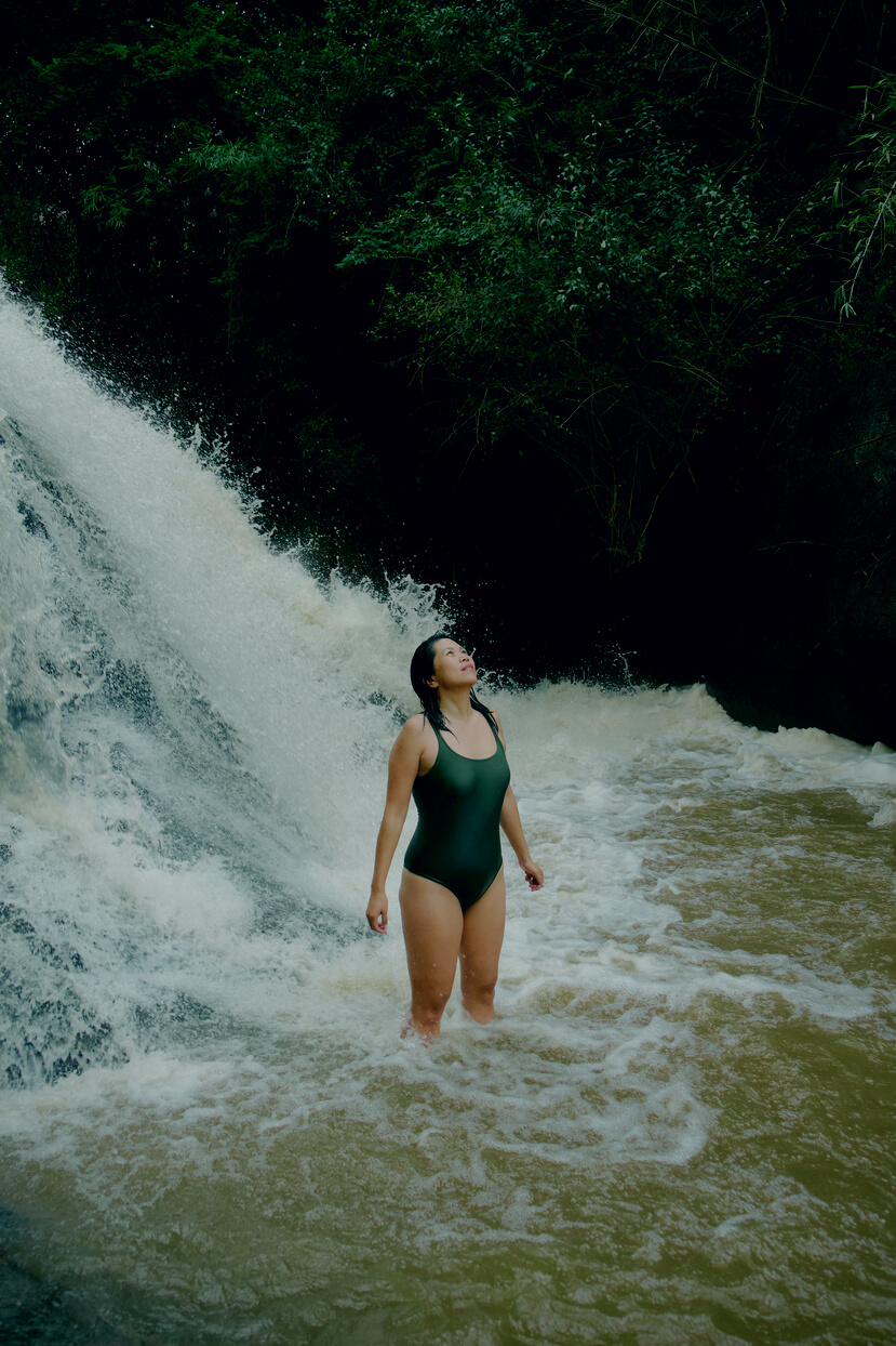 Travel: Tree Climbing Woman in Swimsuit by a Waterfall